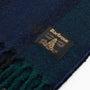 Barbour WESTERDALE Scarf Unisex Adults Green Loch detailed view with woven brand label on dark fabric.