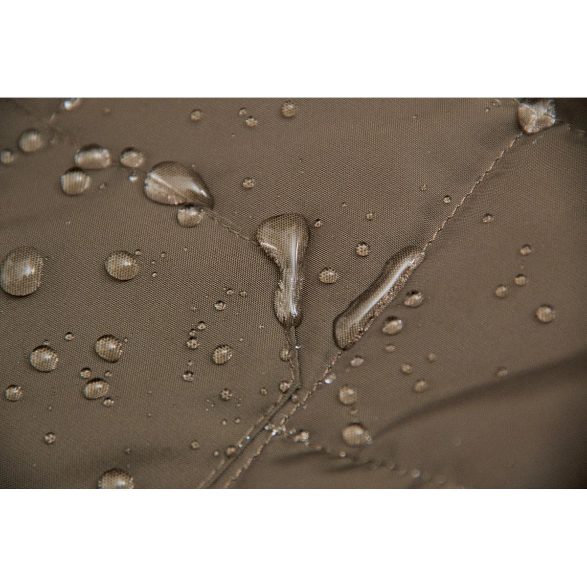 Detail view of the water-repellent material of the CAT TERRAIN Mens Jacket Dark Green, showcasing droplets on the fabric.
