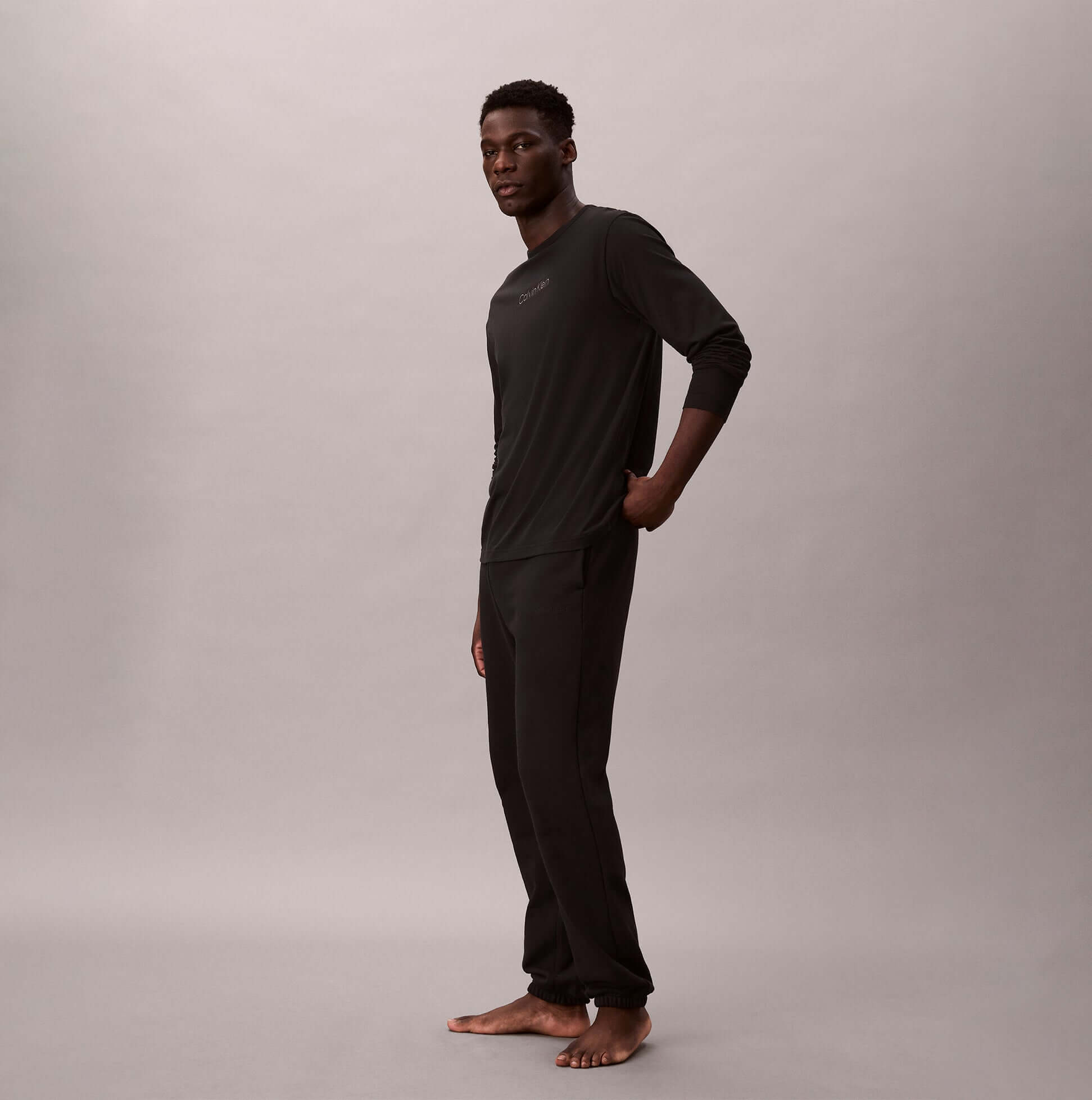 Calvin Klein LS TEE JOGGER SET Mens Multicoloured side view of model wearing black long-sleeve tee and jogger pants.