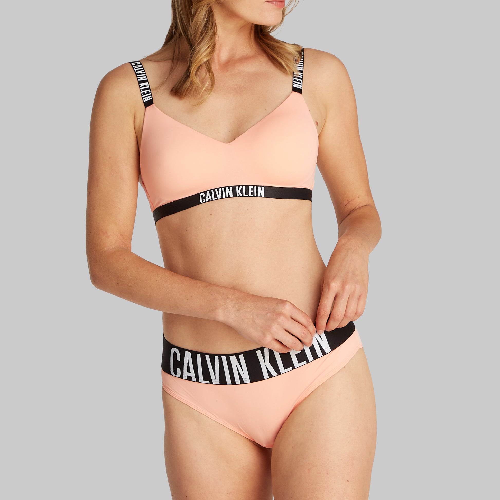 Calvin Klein INTENSE POWER Womens Bralette Papaya Punch side view on model with CK branded waistband