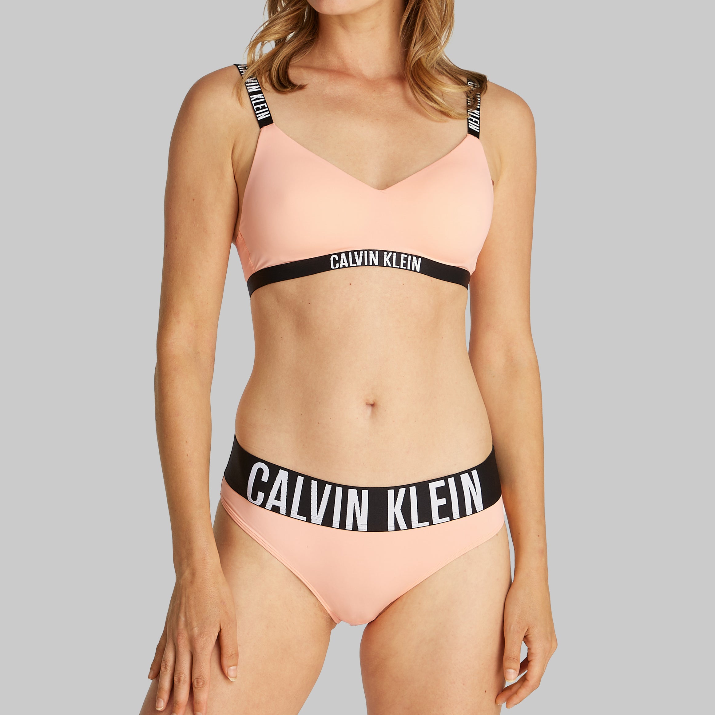 Calvin Klein INTENSE POWER Womens Bikini Briefs Papaya Punch side view on model wearing matching bralette.