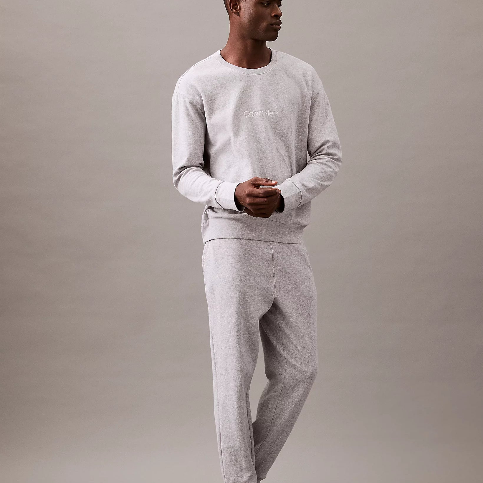 Calvin Klein MODERN TERRY Mens Sweatshirt Grey Heather front view on model standing, showcasing casual style.