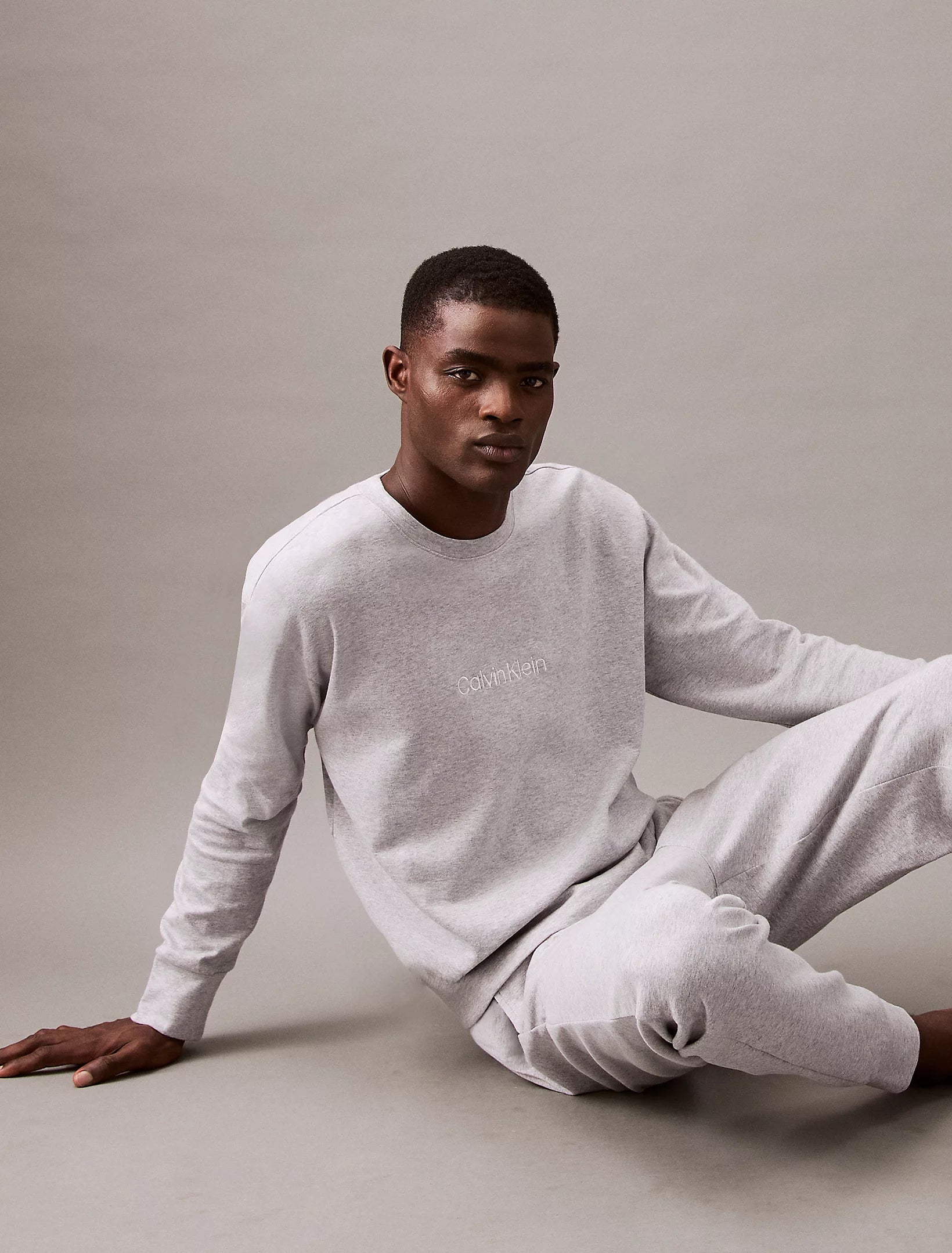Calvin Klein MODERN TERRY Mens Sweatshirt Grey Heather front view on model sitting casually.