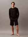 Calvin Klein MODERN TERRY Mens Sweatshirt Black front view model wearing sweatshirt and shorts on gray background