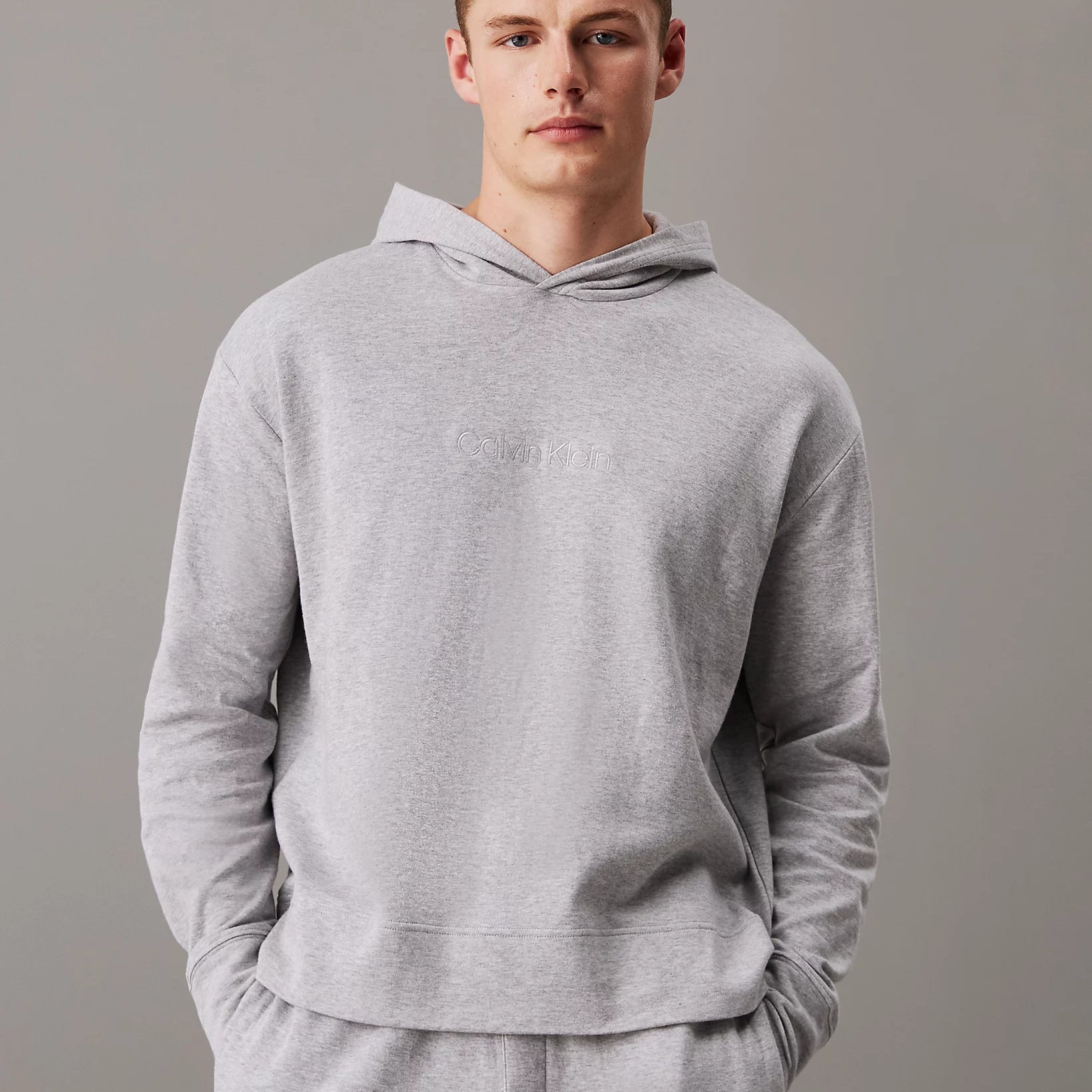 Calvin Klein ICON COTTON TERRY Mens Hoodie Grey front view with model wearing it, showcasing comfort and relaxed fit.