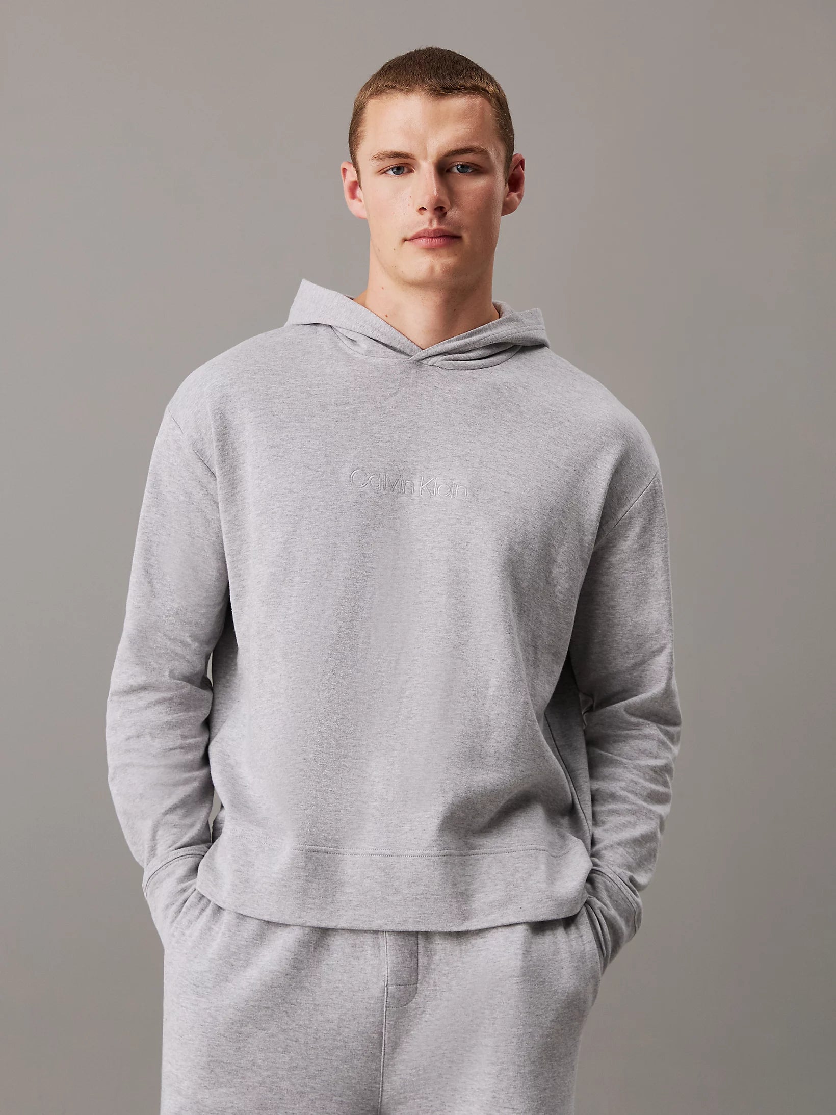 Calvin Klein ICON COTTON TERRY Mens Hoodie Grey front view with model wearing it, showcasing comfort and relaxed fit.