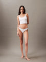 Calvin Klein MODERN LOGO Womens Thong Classic White, front view wearing white thong and tank top against a neutral background.