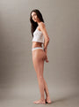 Calvin Klein MODERN LOGO Womens Thong Classic White side view model wearing thong with CK signature waistband