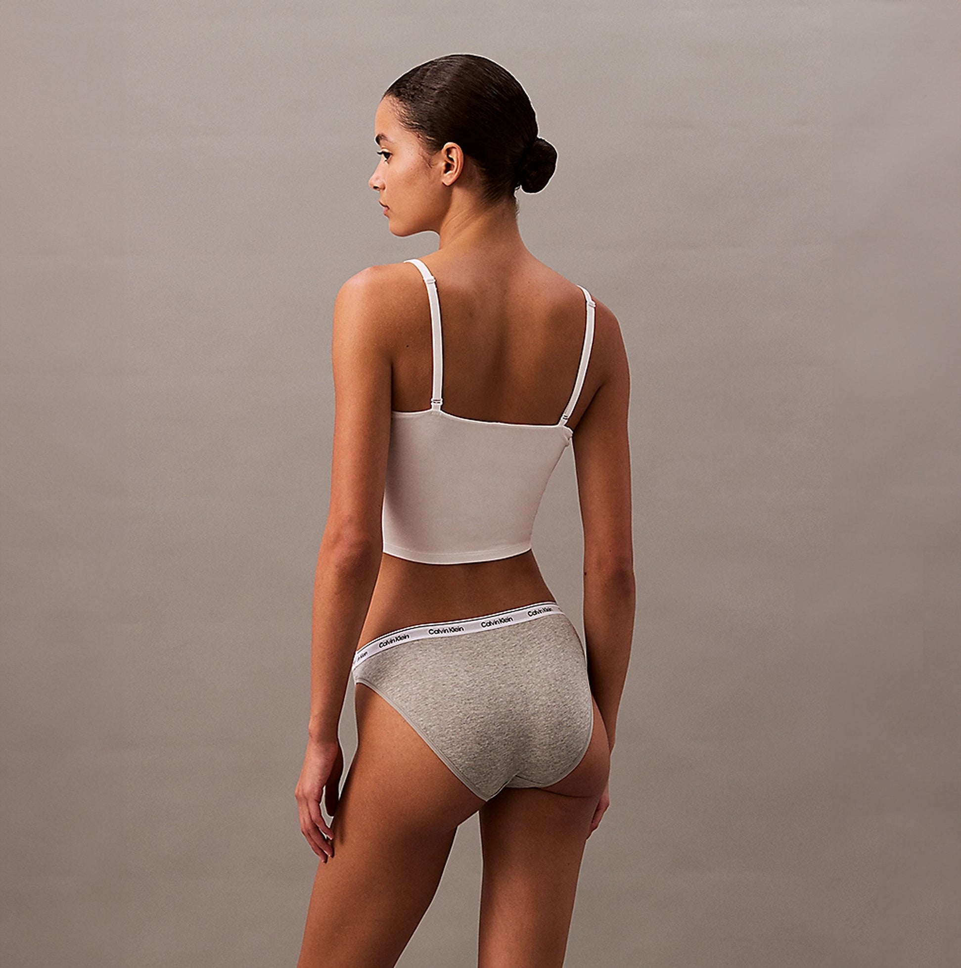 Calvin Klein MODERN LOGO Womens 3 Pack Low Rise Bikini Briefs Multicoloured, side view of model wearing grey bikini briefs and white top.