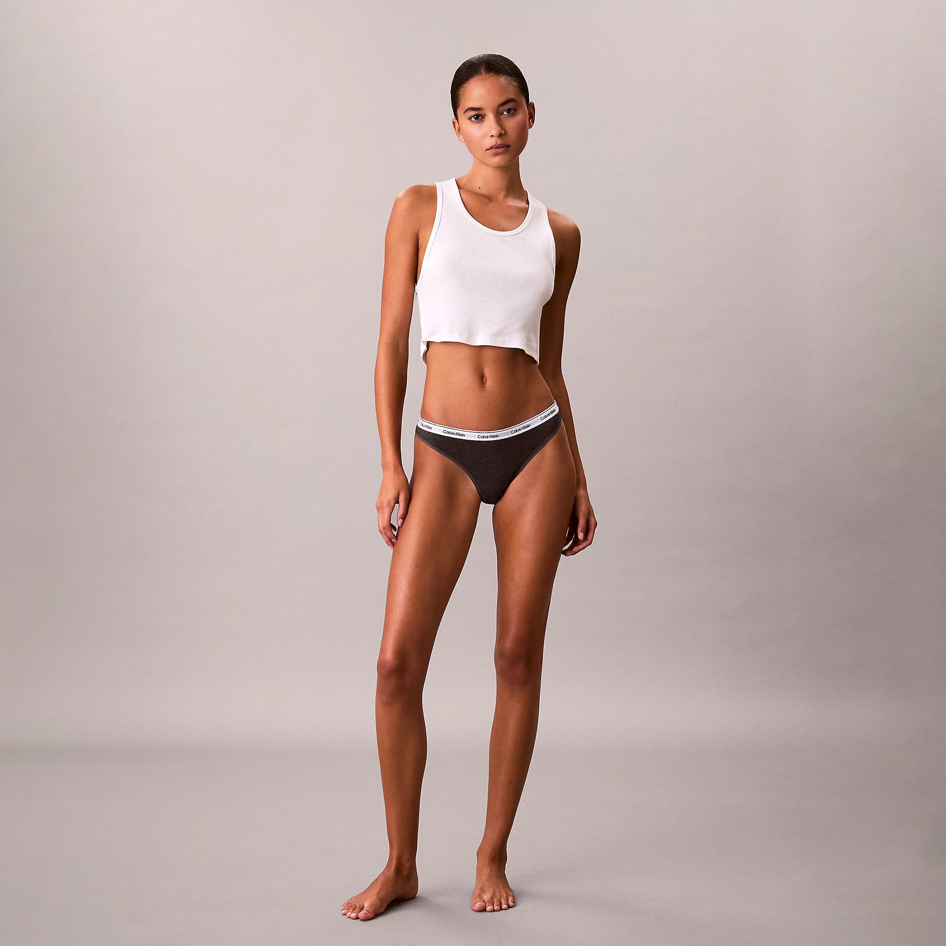Calvin Klein THONG 3 PACK Womens Thong Multicoloured side view model wearing a white crop top and dark thong.