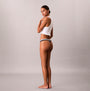 Calvin Klein THONG 3 PACK Womens Thong Multicoloured side view on model wearing a white crop top and multicoloured thong.