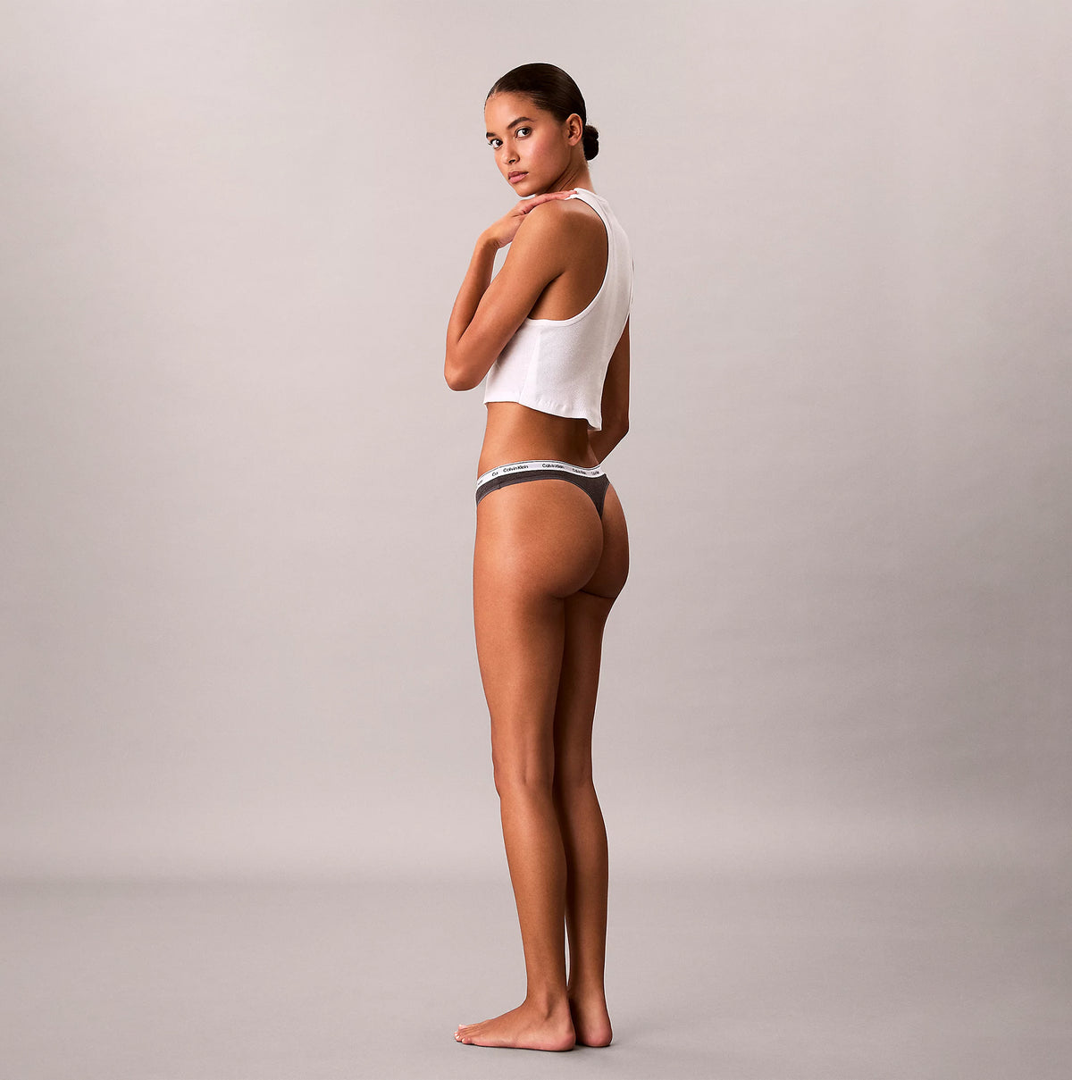 Calvin Klein THONG 3 PACK Womens Thong Multicoloured side view on model wearing a white crop top and multicoloured thong.