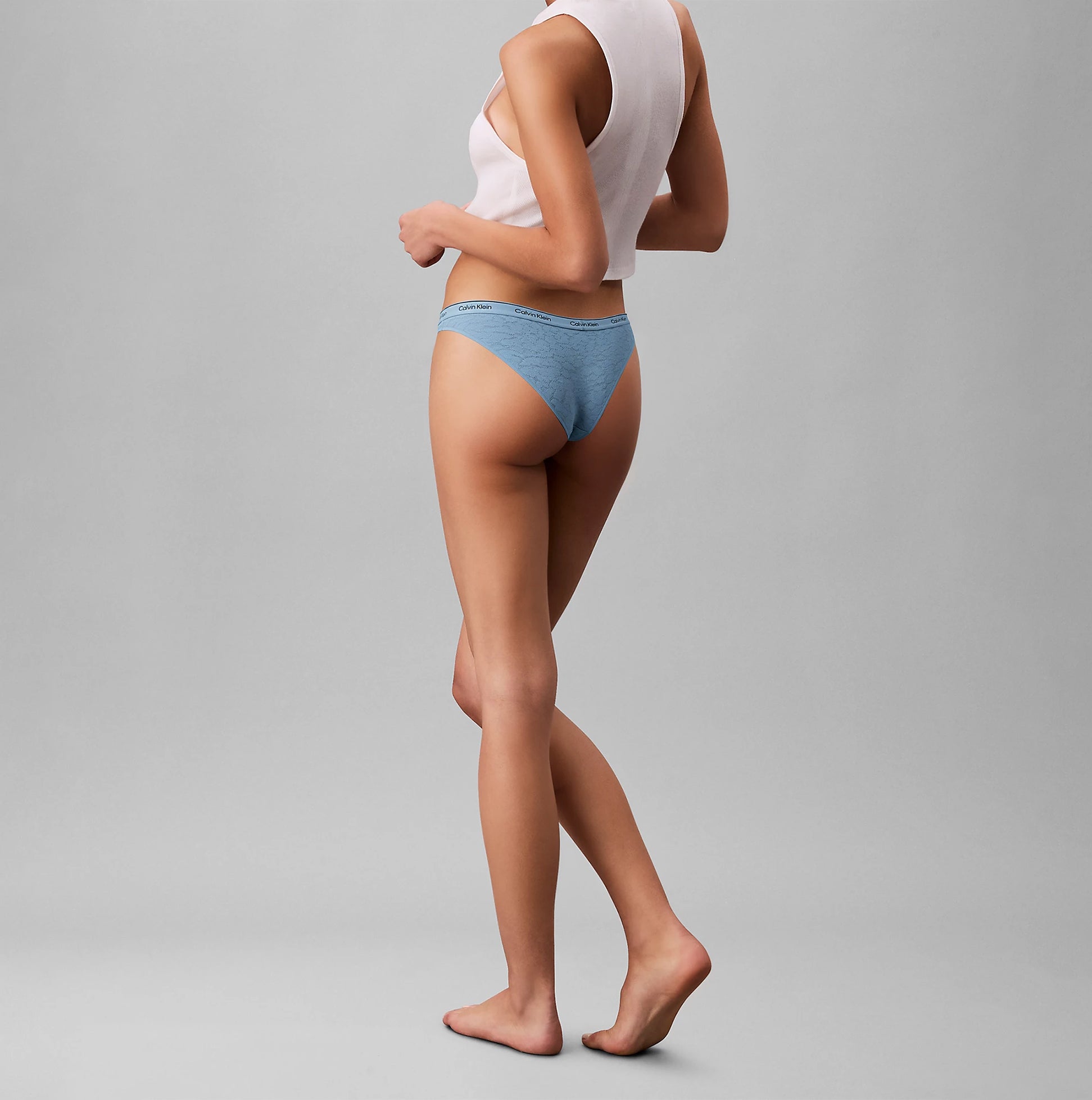Calvin Klein BRAZILIAN 3 PACK Womens Multicoloured side view of model wearing blue Brazilian underwear.