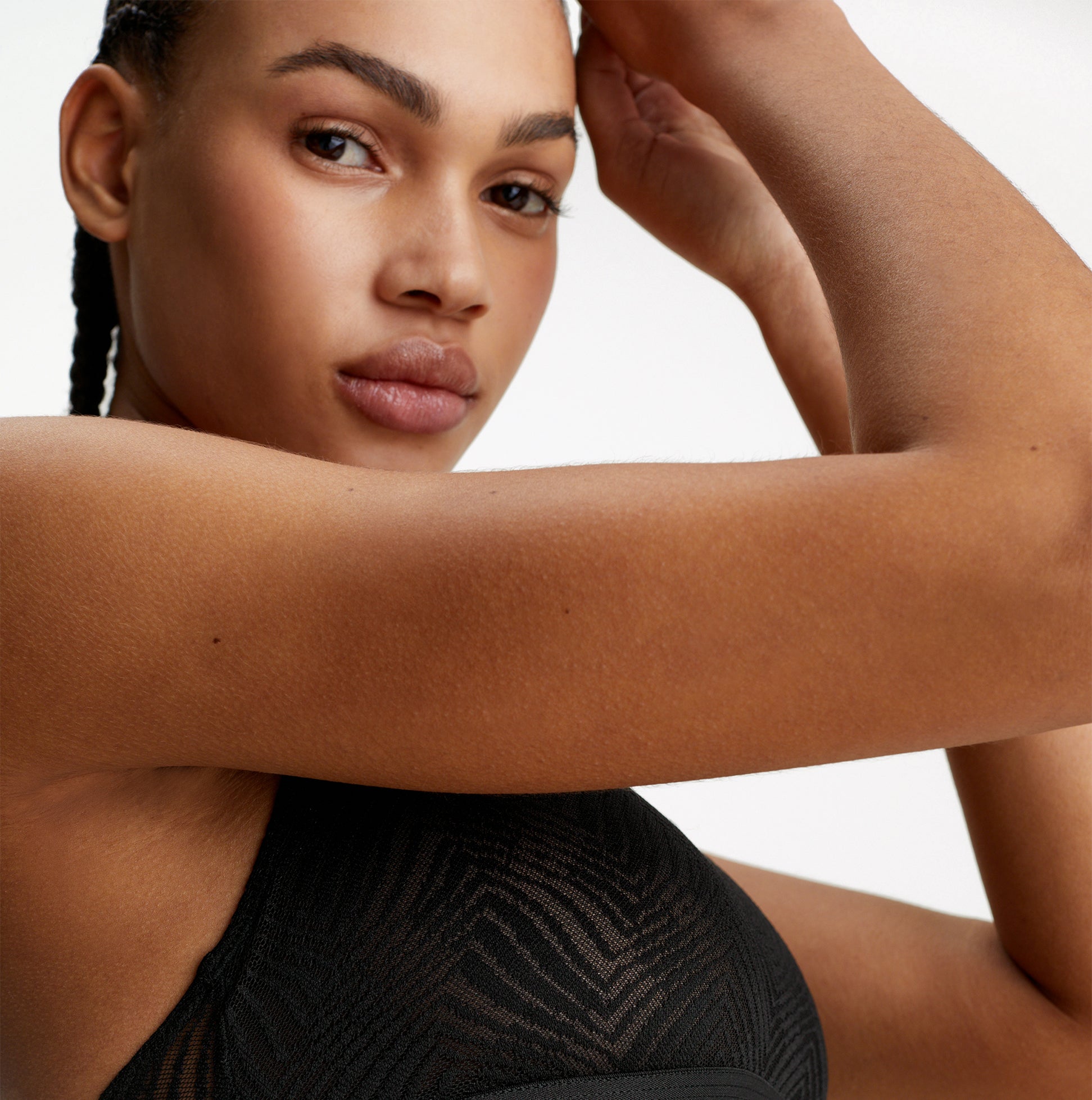 Calvin Klein LACE Unlined Bralette Womens Black detail view on model showcasing semi-sheer graphic lace and racerback design.