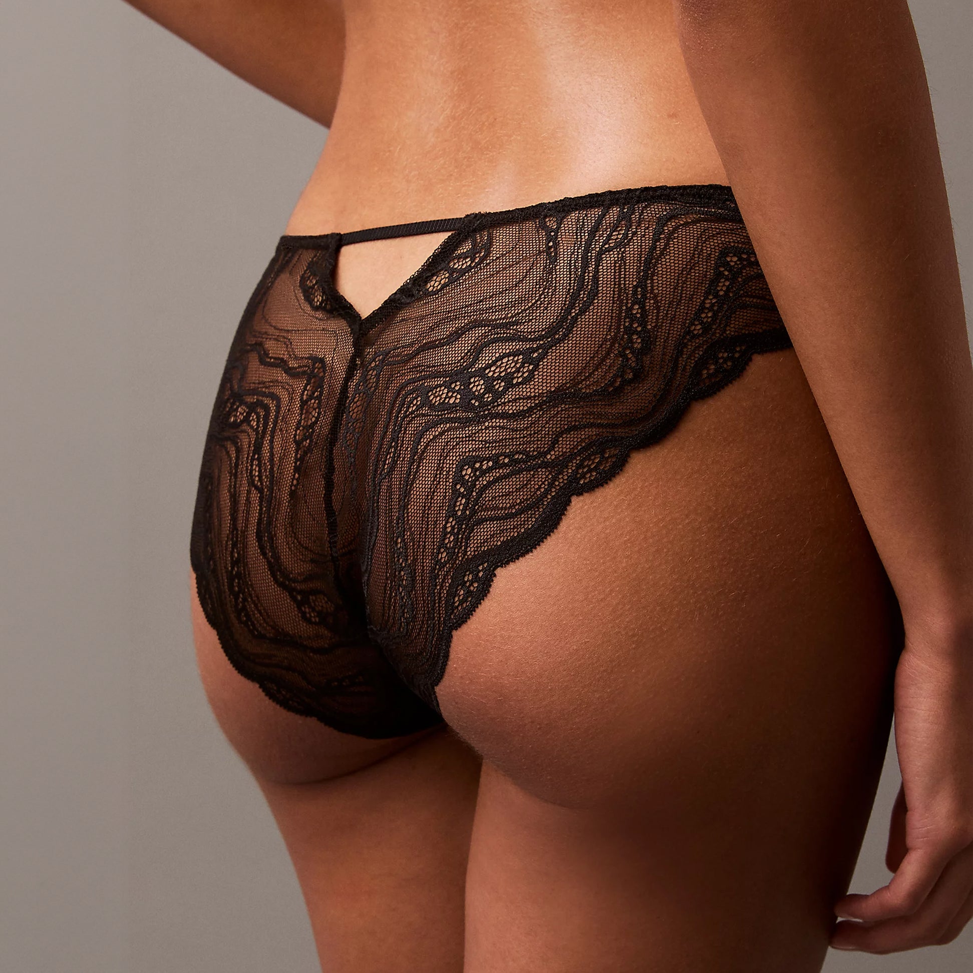 Calvin Klein CK INSTINCT Womens Bikinis Black, back view highlighting lace detail and scalloped edges.