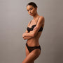 Calvin Klein CK INSTINCT Womens Bikinis Black side view model wearing bikini with lace detail and strappy design.