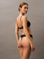Calvin Klein TONAL LOGO COTTON Womens Thong Black back view with model showcasing the thong's fit and design.