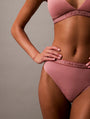 Calvin Klein TONAL LOGO COTTON Womens Thong Red Grape W/ Apple Butter Logo side view on model, showcasing the logo and fit.