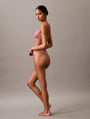 Calvin Klein TONAL LOGO COTTON Womens Thong Red Grape W/ Apple Butter Logo side view on model.