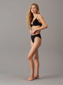 Calvin Klein ICON LACE Womens Tanga Black side view model wearing black lace and polyamide underwear
