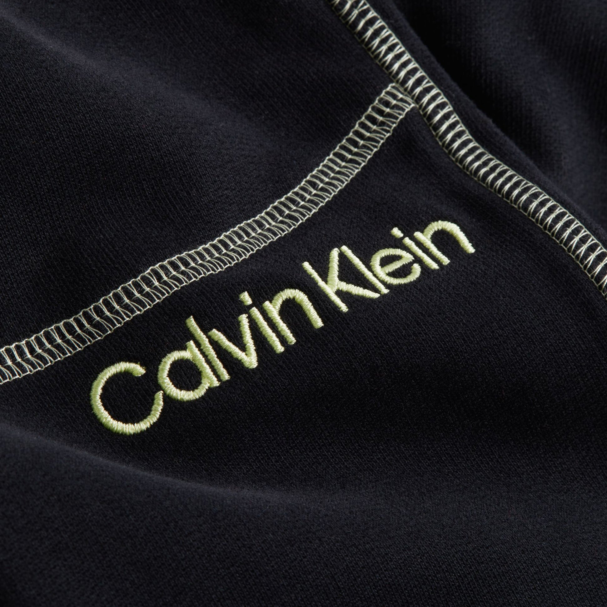 Calvin Klein FUTURE SHIFT Womens Joggers Black detail view of logo embroidery on fabric.