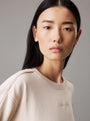 Calvin Klein COTTON FLEECE Womens Crew Pullover Sandshell front view worn by model, showcasing soft fabric and logo detail.