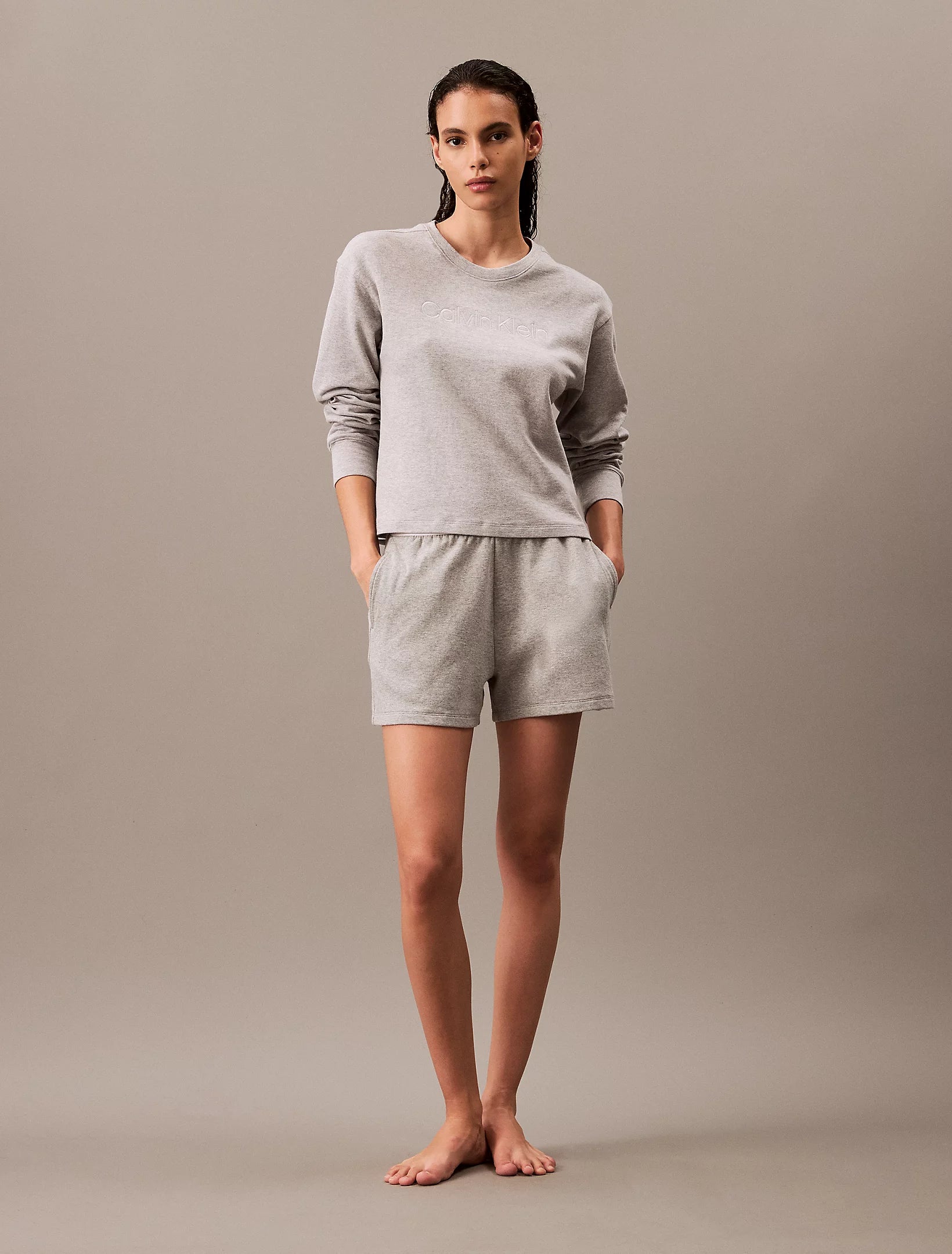 Calvin Klein MODERN TERRY Womens Sweatshirt Grey Heather front view with casual shorts, model standing barefoot.