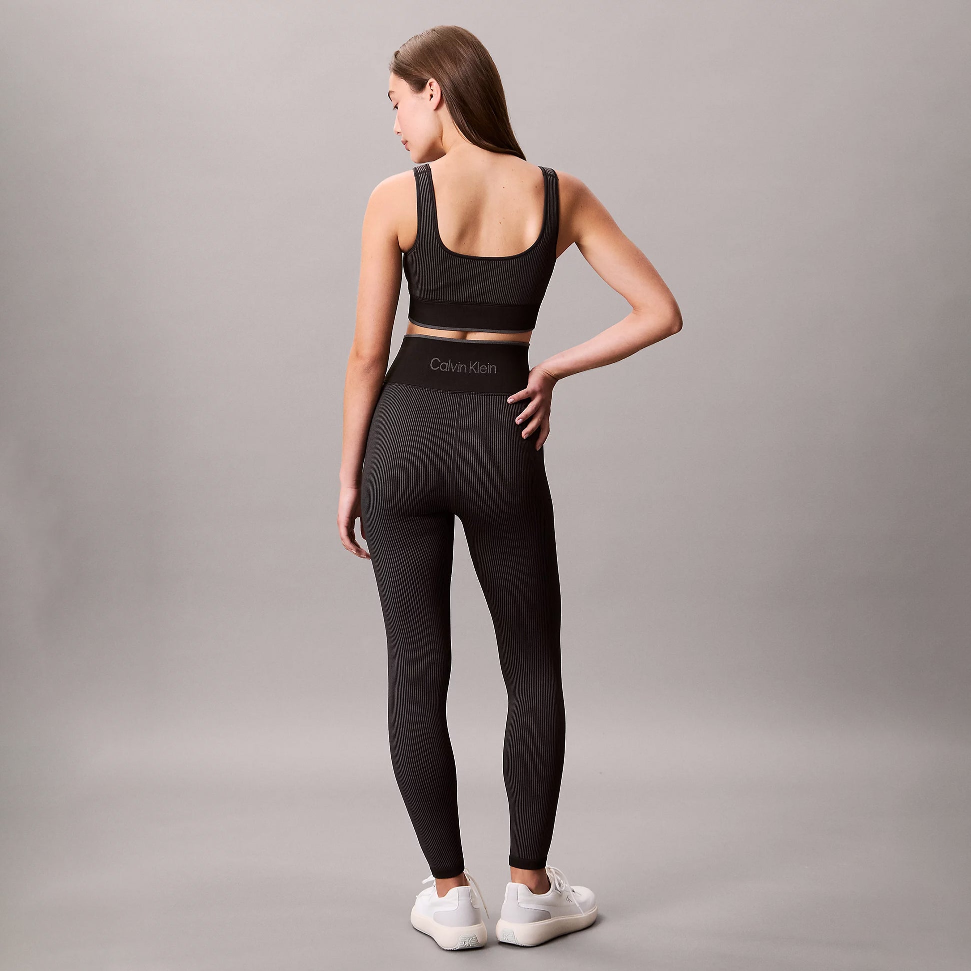 Calvin Klein Medium Impact Sports Bra back view on model, black color, showing pull-on design and snug fit.