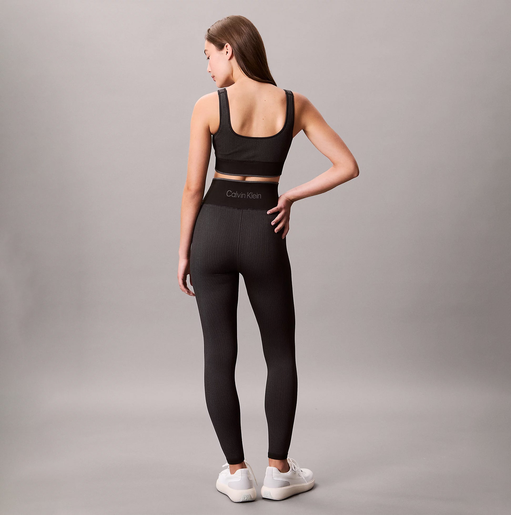 Calvin Klein Medium Impact Sports Bra back view on model, black color, showing pull-on design and snug fit.