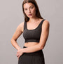 Calvin Klein Medium Impact Womens Sports Bra Black front view with model wearing it, showing ribbed texture and brand logo.