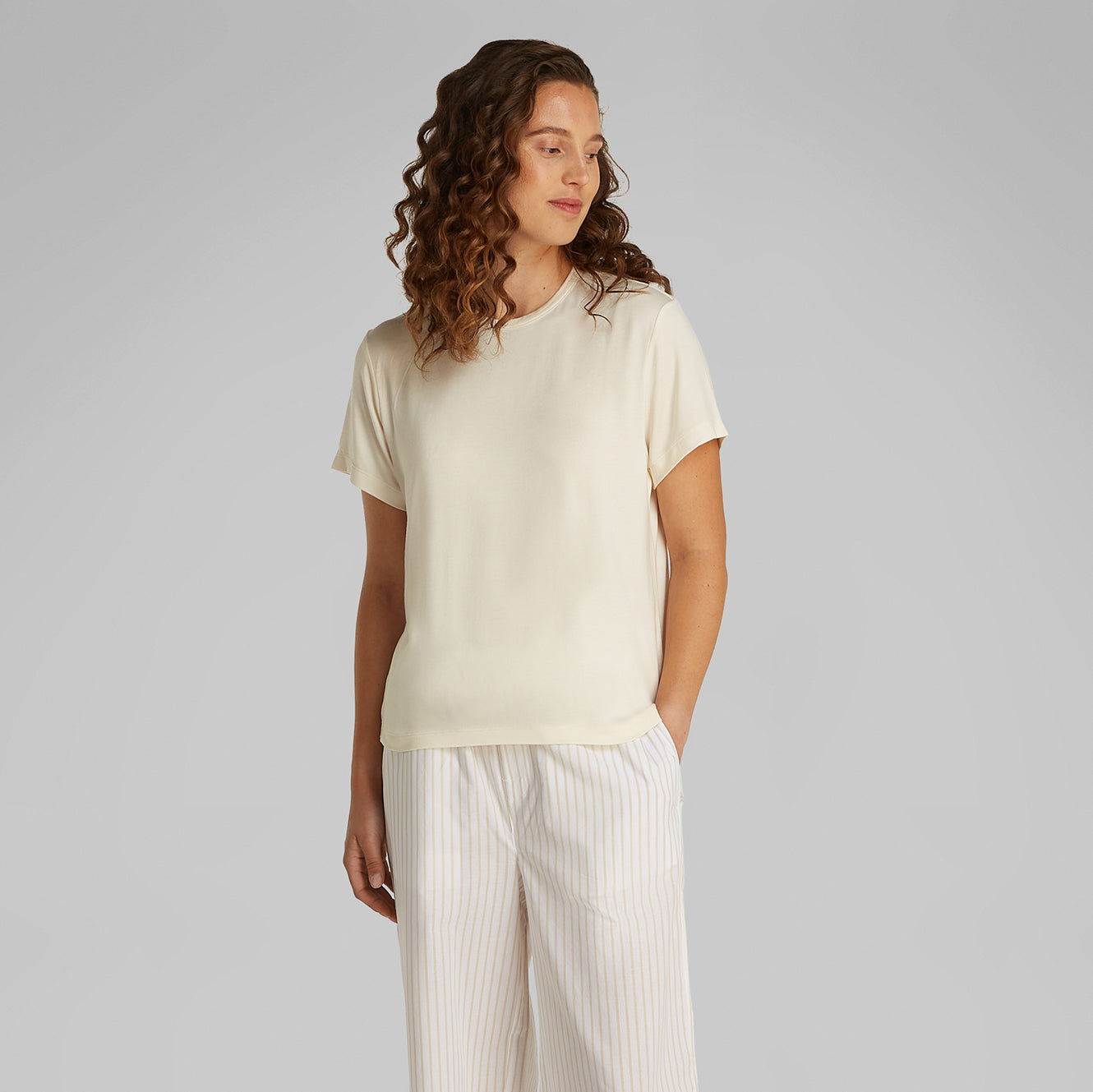 Calvin Klein ULTRA SOFT MODAL Womens Lounge T-Shirt Ivory front view, short sleeves, relaxed fit, worn with striped pants.