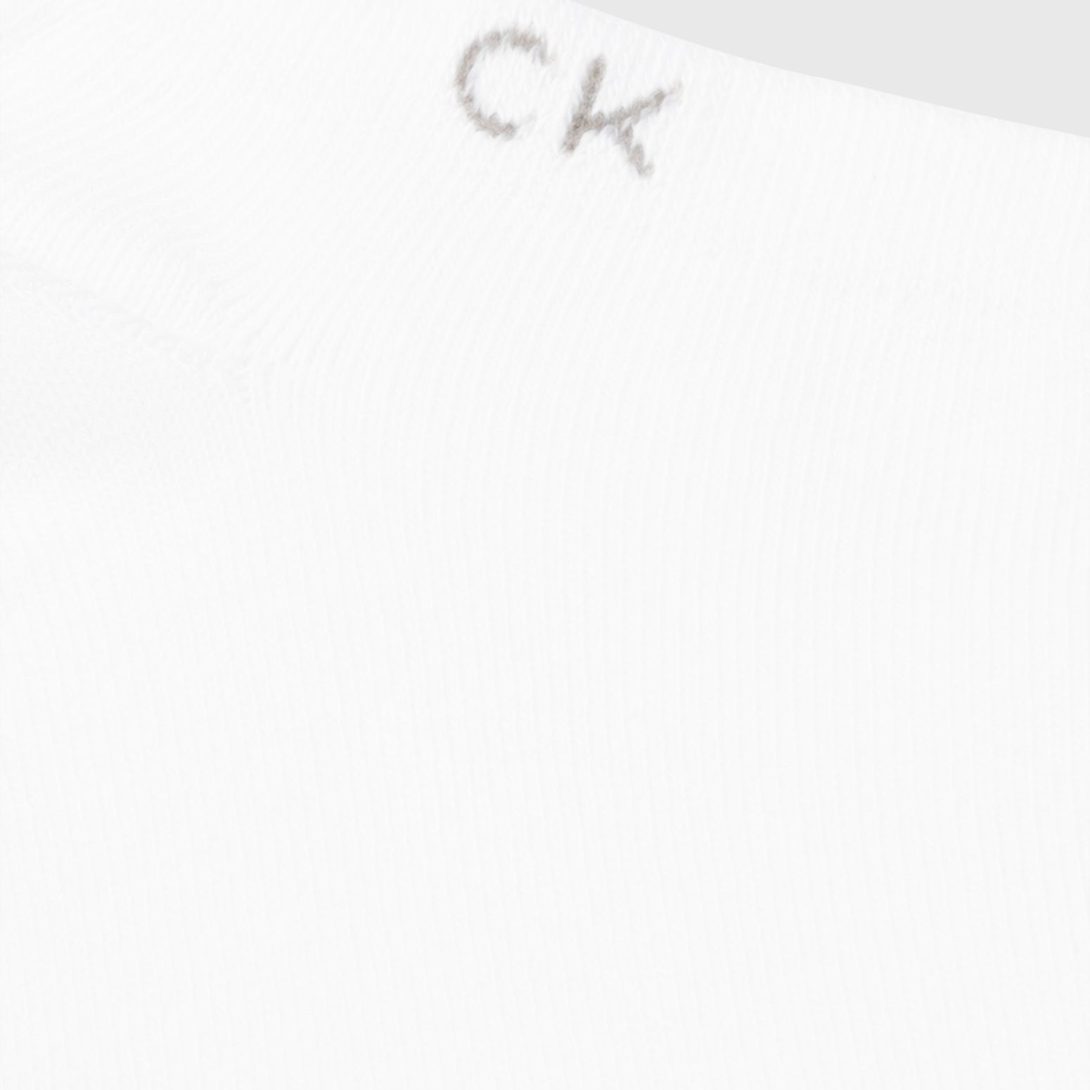 Calvin Klein 2 Pack Mens Ankle Trainer Socks White close-up detail view featuring CK logo on the cuff.