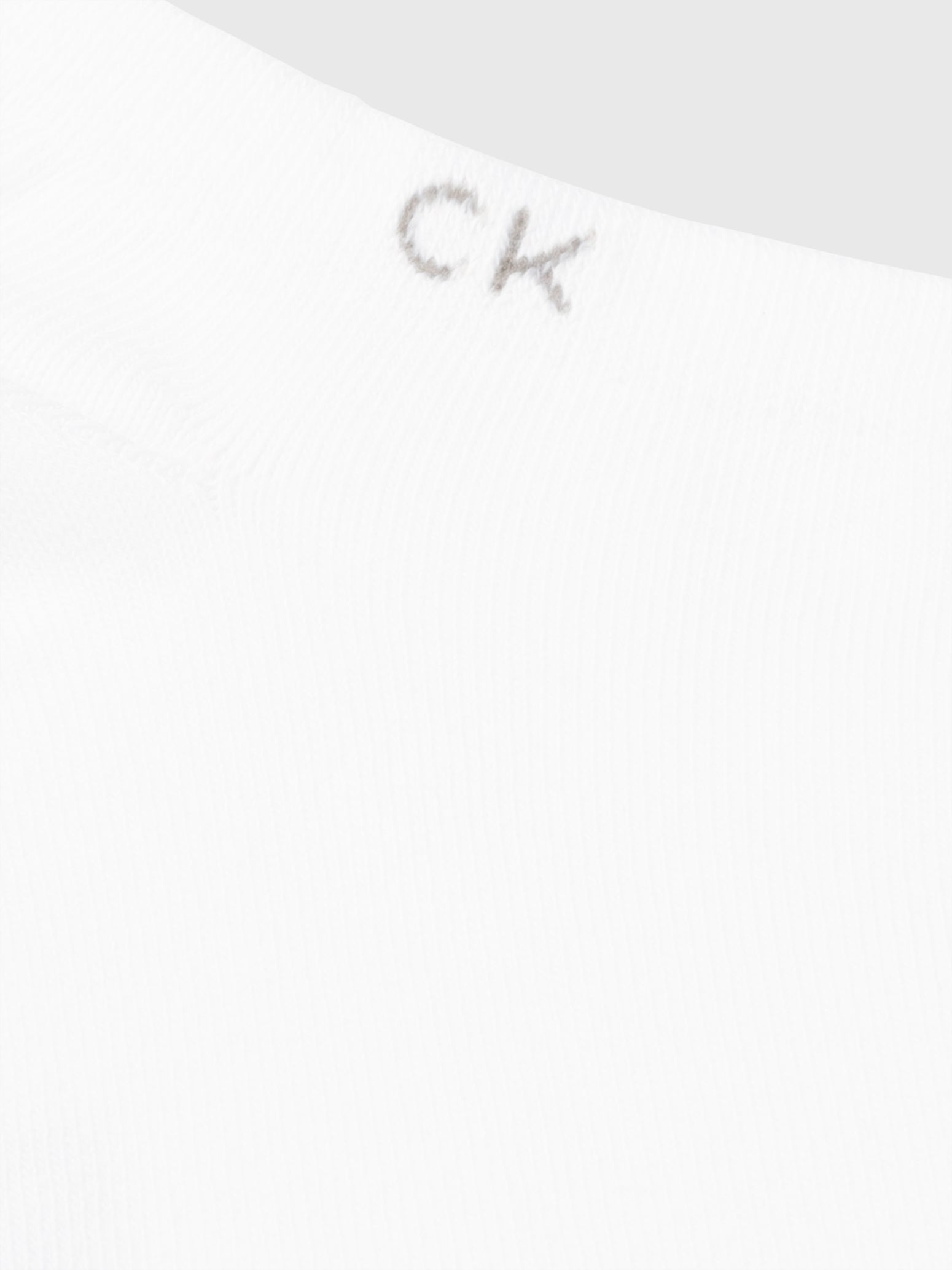 Calvin Klein 2 Pack Mens Ankle Trainer Socks White close-up detail view featuring CK logo on the cuff.