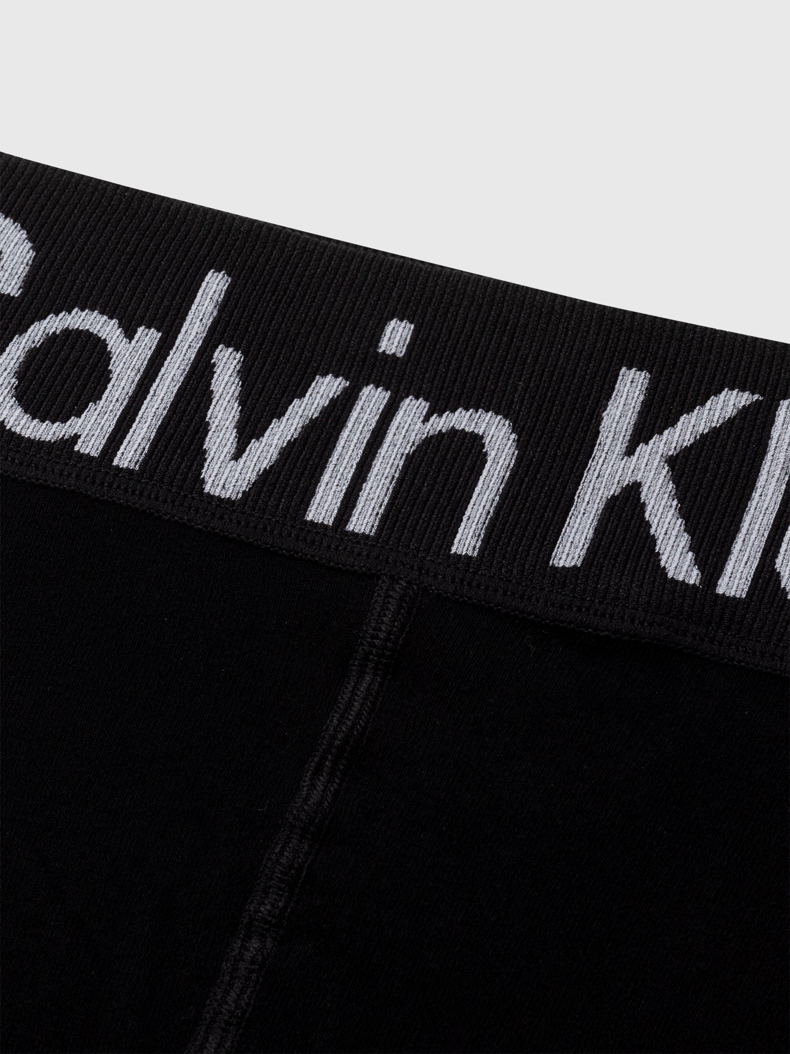 Calvin Klein LOGO Waist Leggings Black close-up view of waistband featuring CK logo in grey on black fabric.