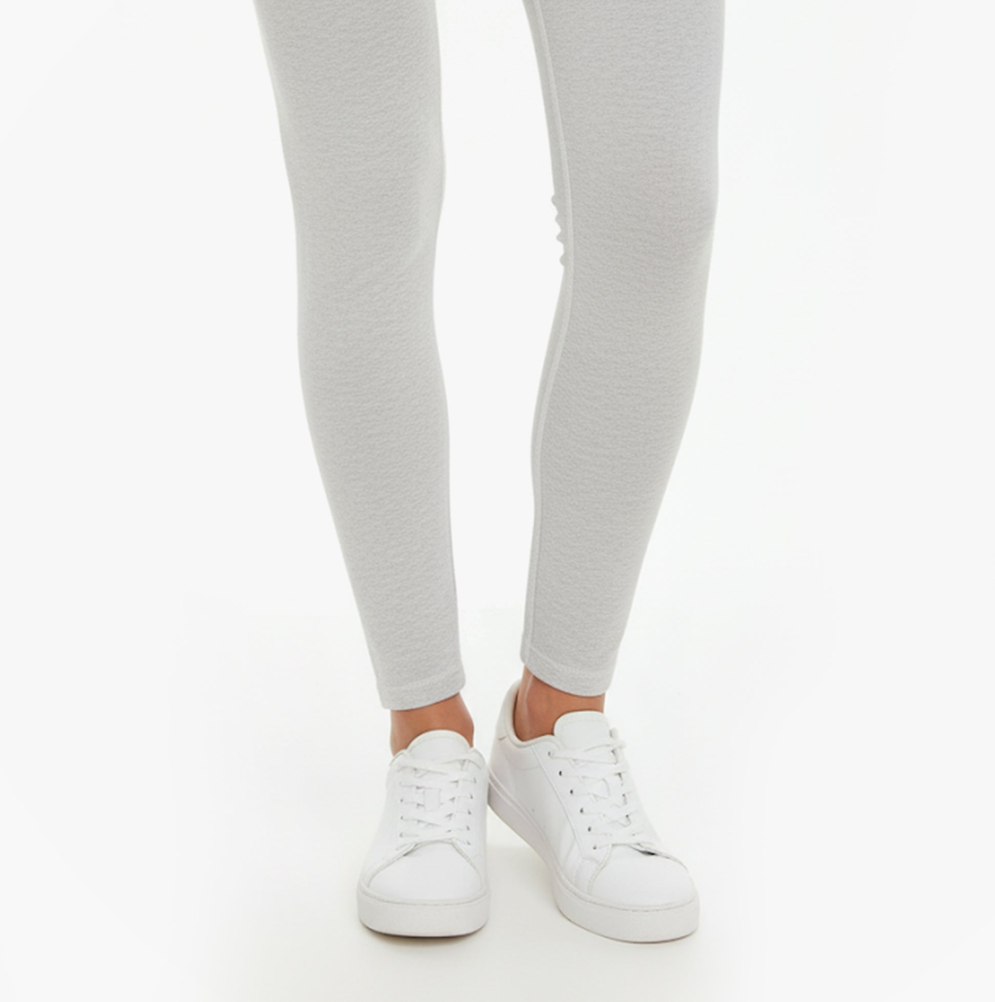 Calvin Klein LOGO Waist Leggings Grey front view with white sneakers, showcasing slim fit and comfort material.