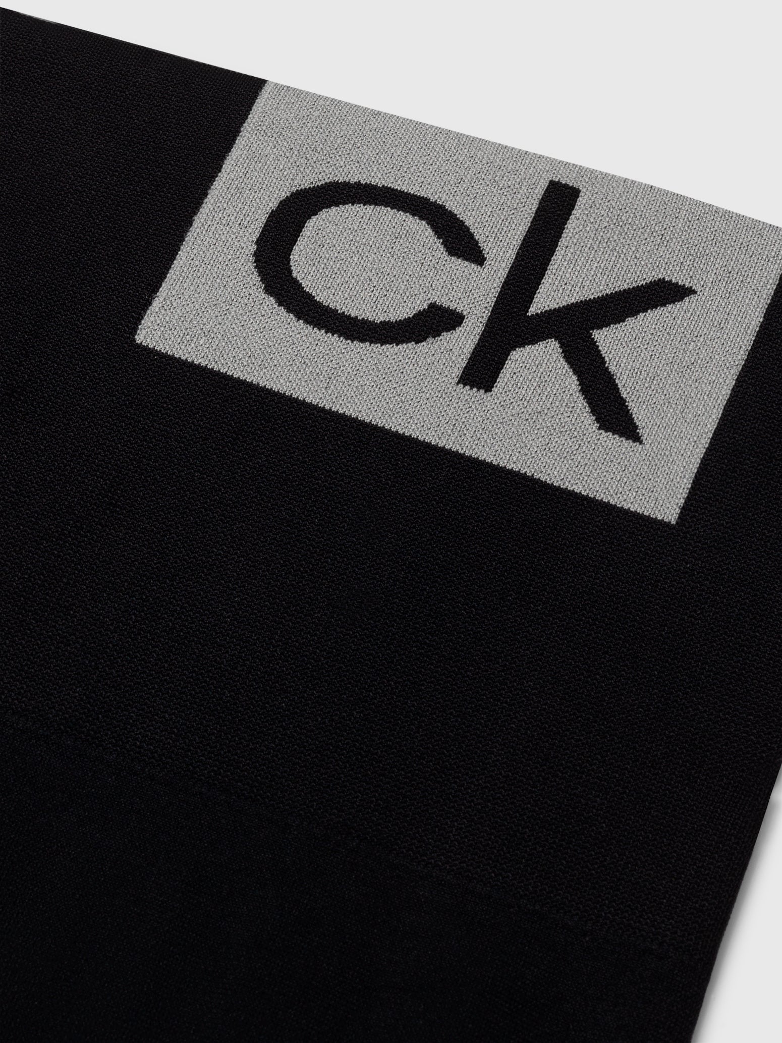 Calvin Klein LOGO Gym Leggings Black detail view of CK logo on fabric, showcasing sleek design and quality material.