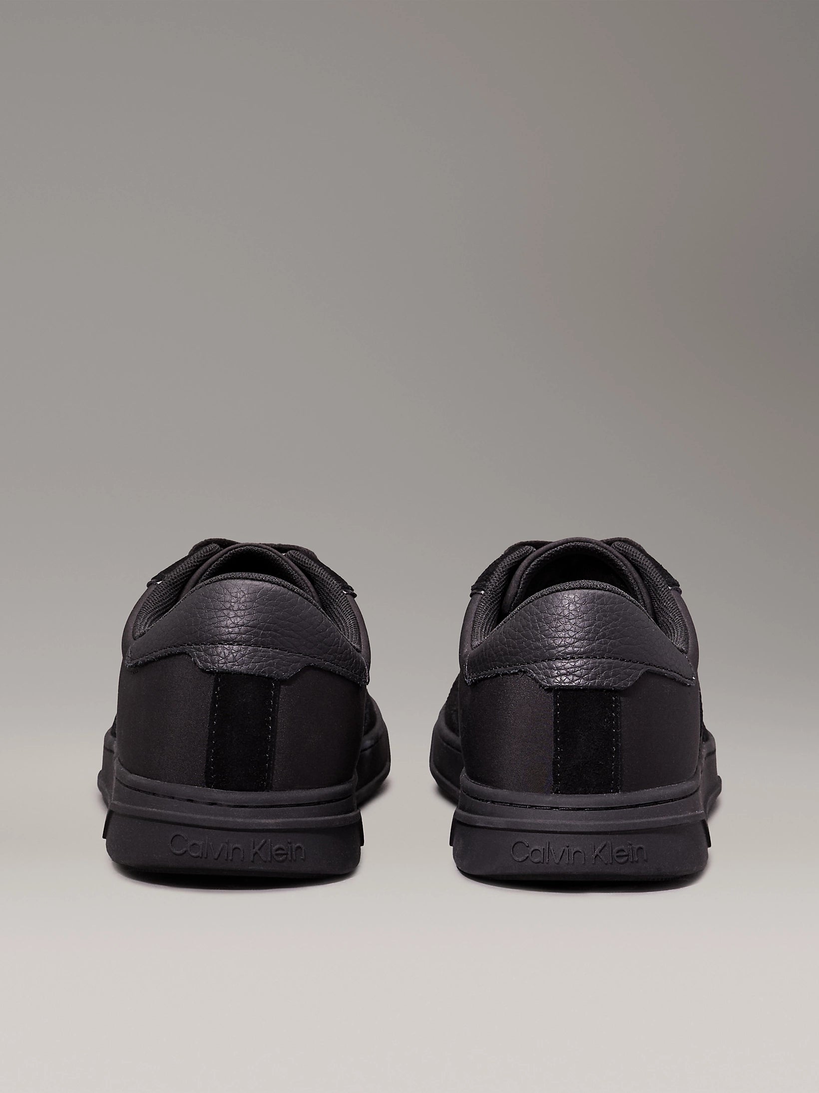 Calvin Klein LOW TOP LACE UP MIX Mens Trainers Triple Black rear view showing sleek design and low top silhouette.