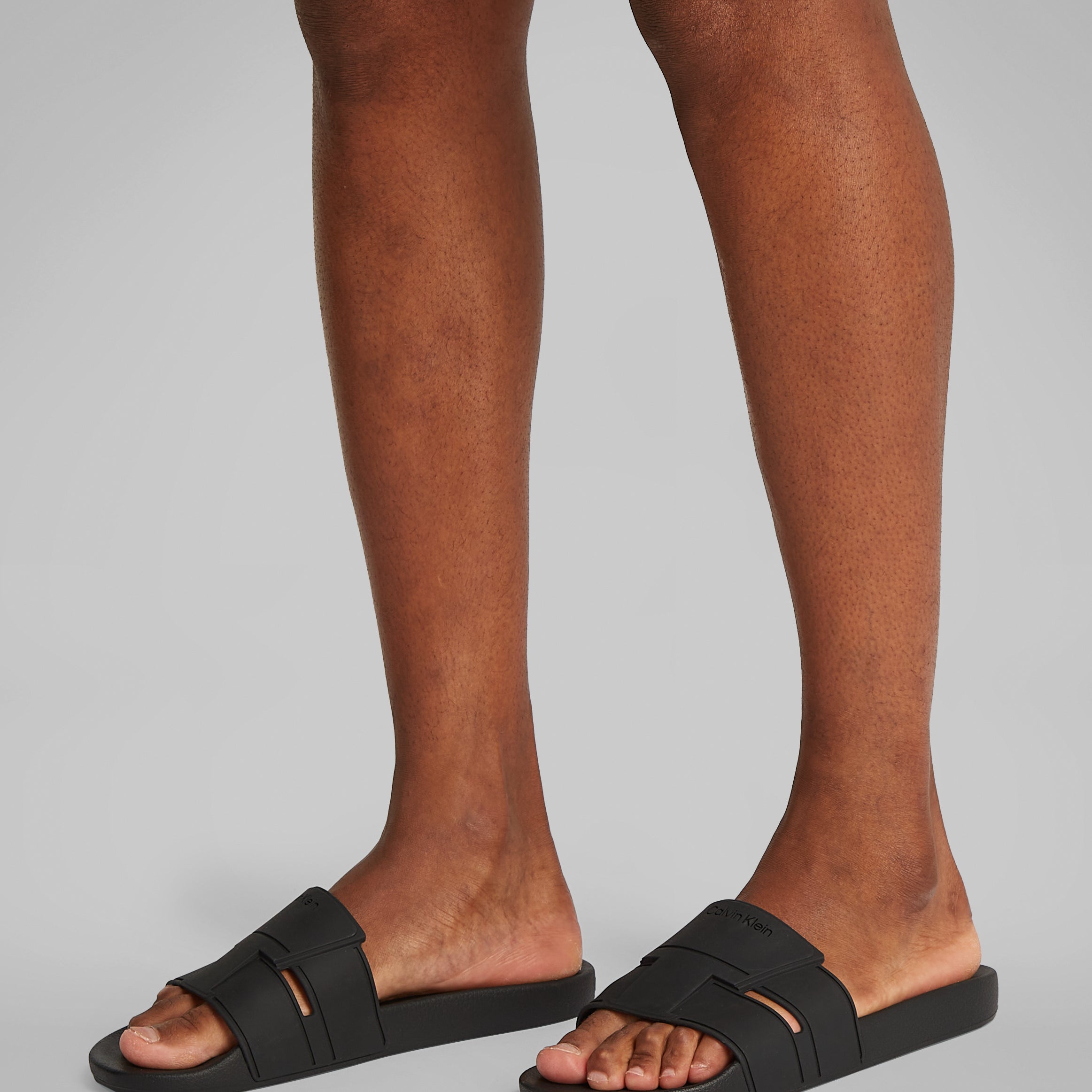 Calvin Klein POOL SLIDE DOUBLE T Mens Sliders Ck Black side view worn on feet, showing comfort and lightweight design.