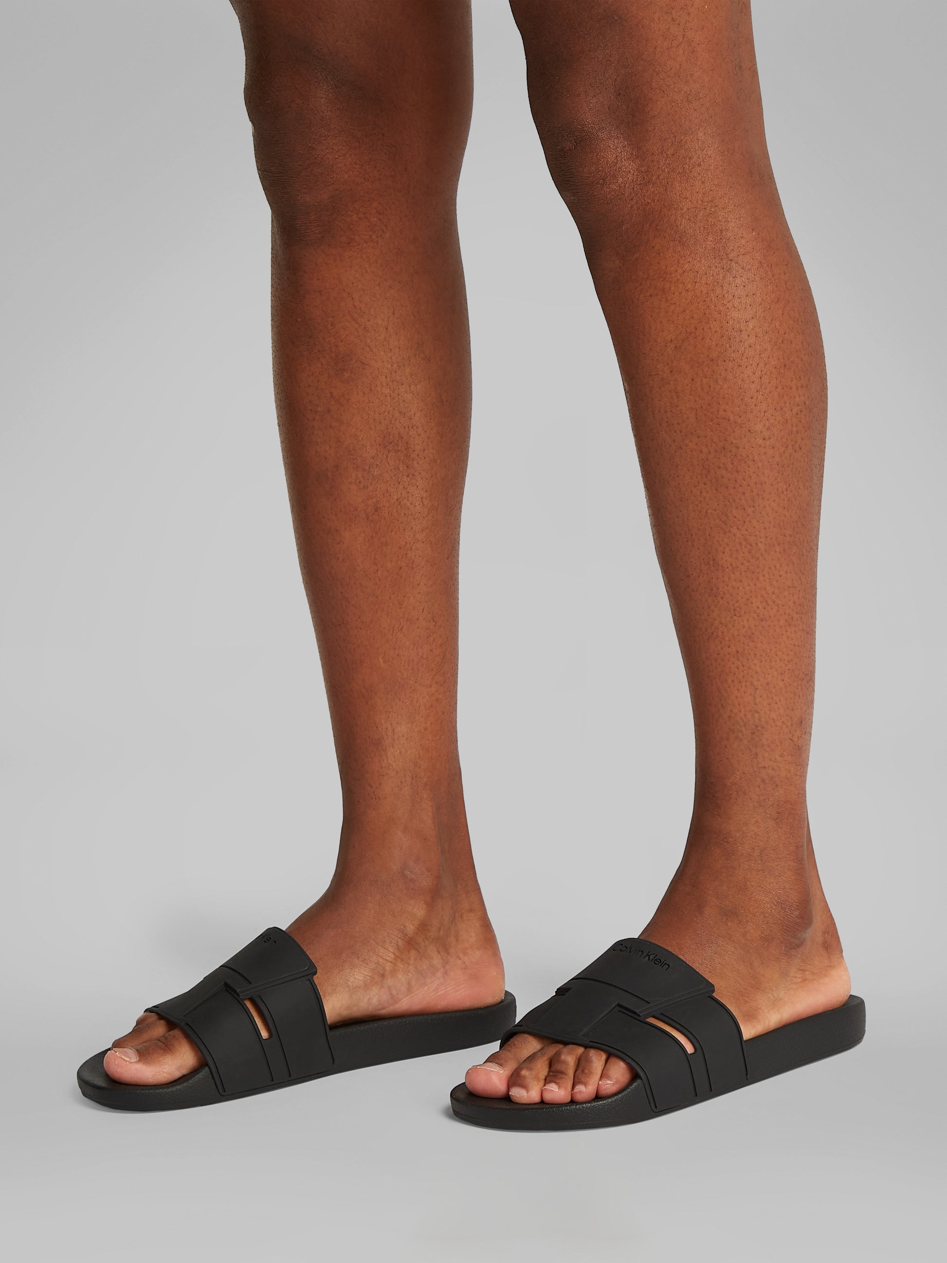Calvin Klein POOL SLIDE DOUBLE T Mens Sliders Ck Black side view worn on feet, showing comfort and lightweight design.