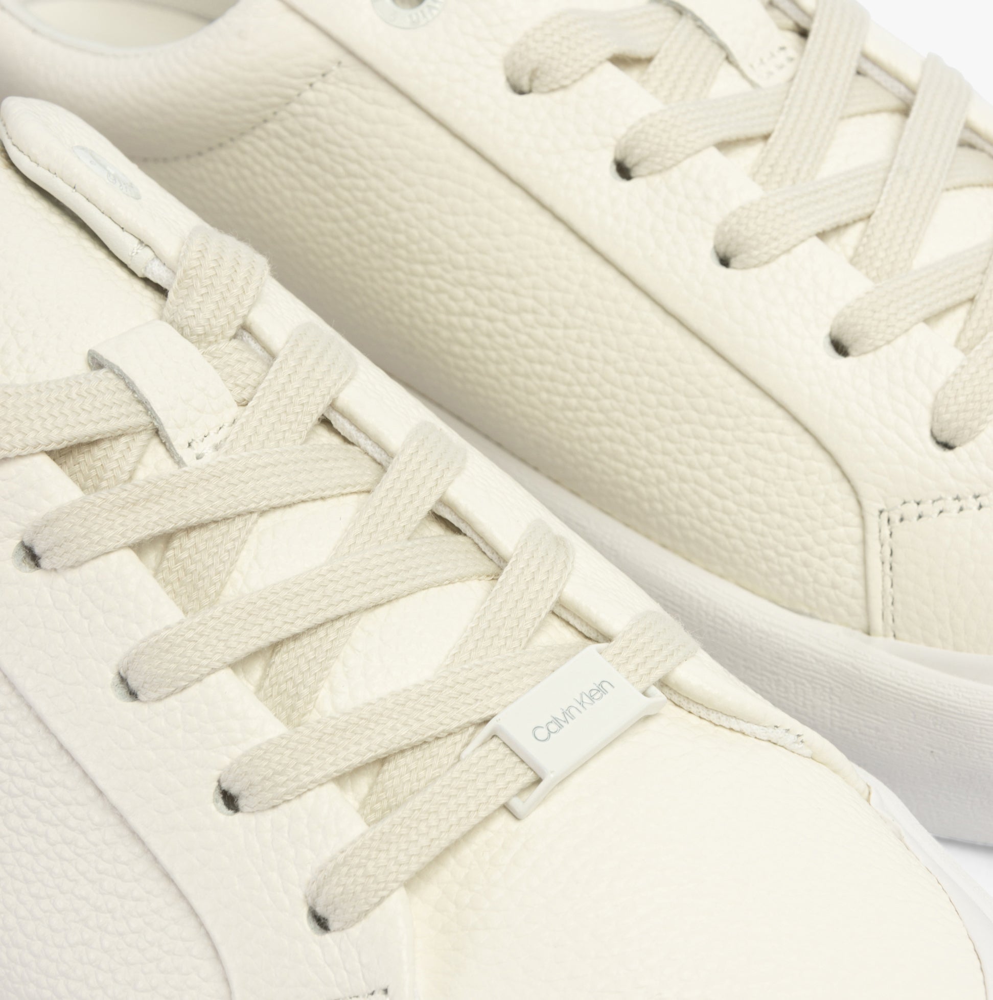 Calvin Klein VULCANISED LACE UP Womens Trainers White/Dk Ecru close-up detail view showing lace-up design and leather material.