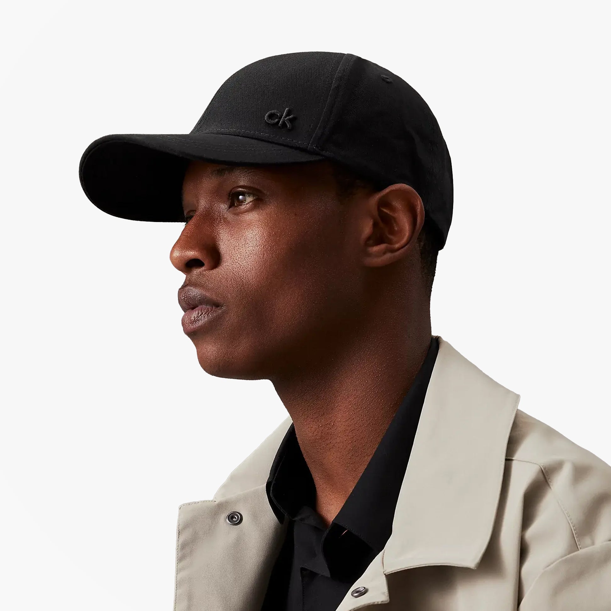 Calvin Klein Mens BASEBALL CAP Black side view on model, showcasing adjustable strap and stylish design.