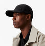 Calvin Klein Mens BASEBALL CAP Black side view on model, showcasing adjustable strap and stylish design.