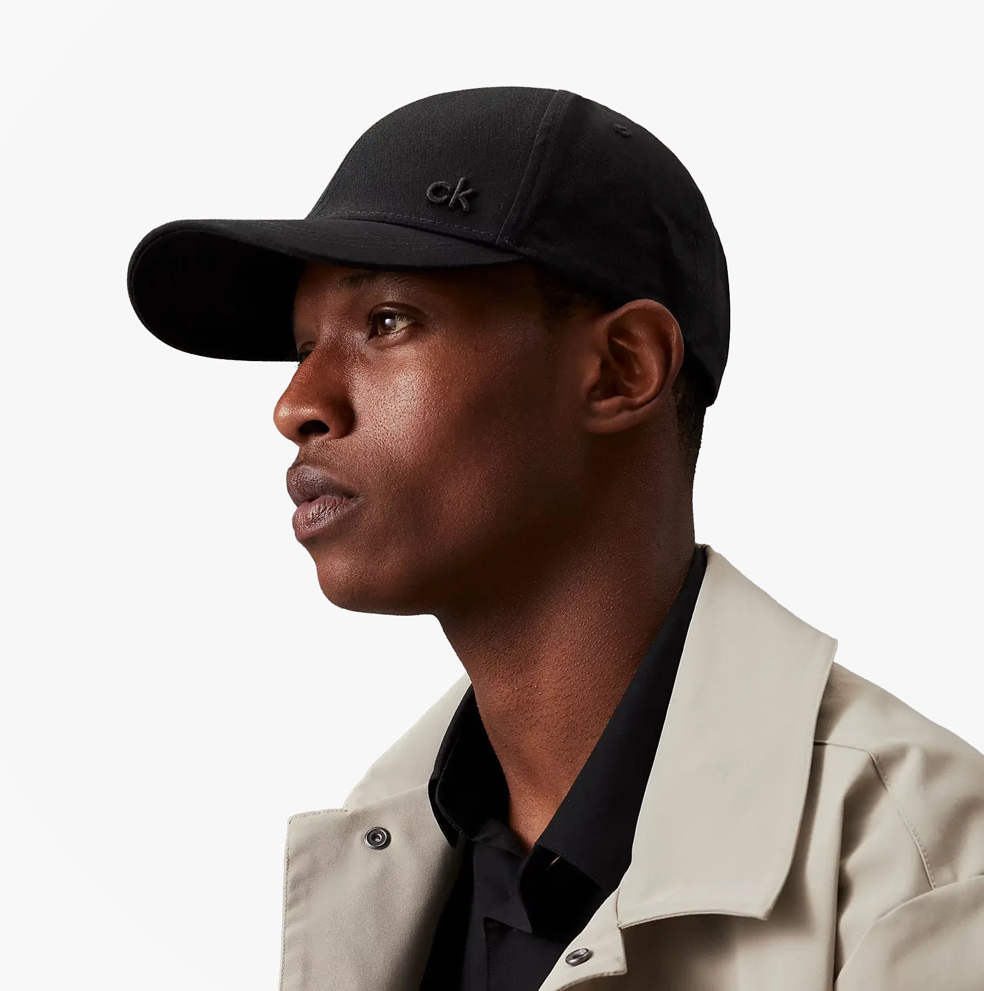 Calvin Klein Mens BASEBALL CAP Black side view on model, showcasing adjustable strap and stylish design.