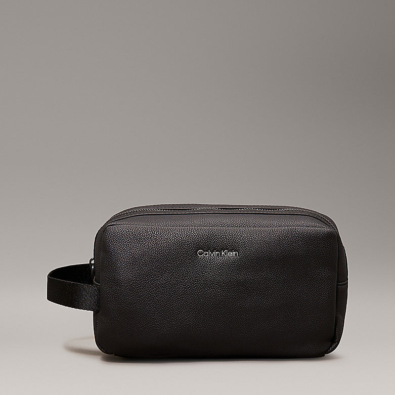 Calvin Klein WARMTH WASHBAG Mens Black front view with zip closure, lightweight faux leather exterior and side handle.