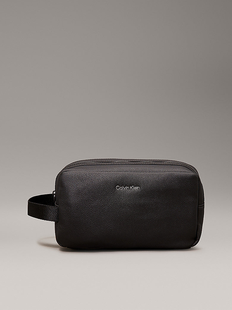 Calvin Klein WARMTH WASHBAG Mens Black front view with zip closure, lightweight faux leather exterior and side handle.