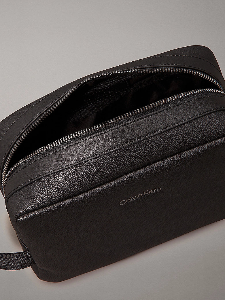 Calvin Klein WARMTH WASHBAG Mens Black top view with zip open, showcasing faux leather texture and CK logo.