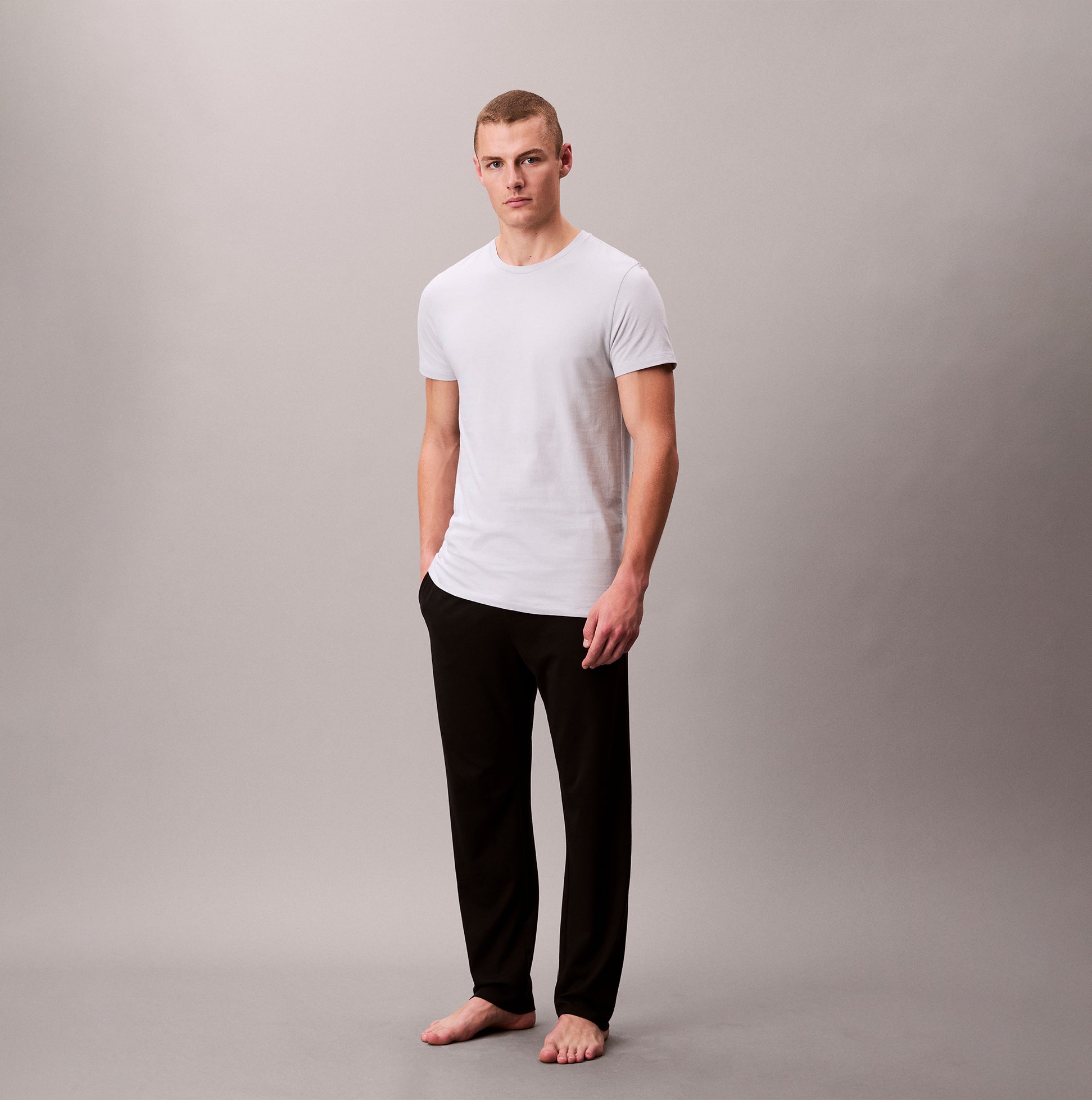 Calvin Klein 3 Pack Mens Crew neck T-Shirt Cotton Classics Multi Colour front view on model wearing white t-shirt and black pants.