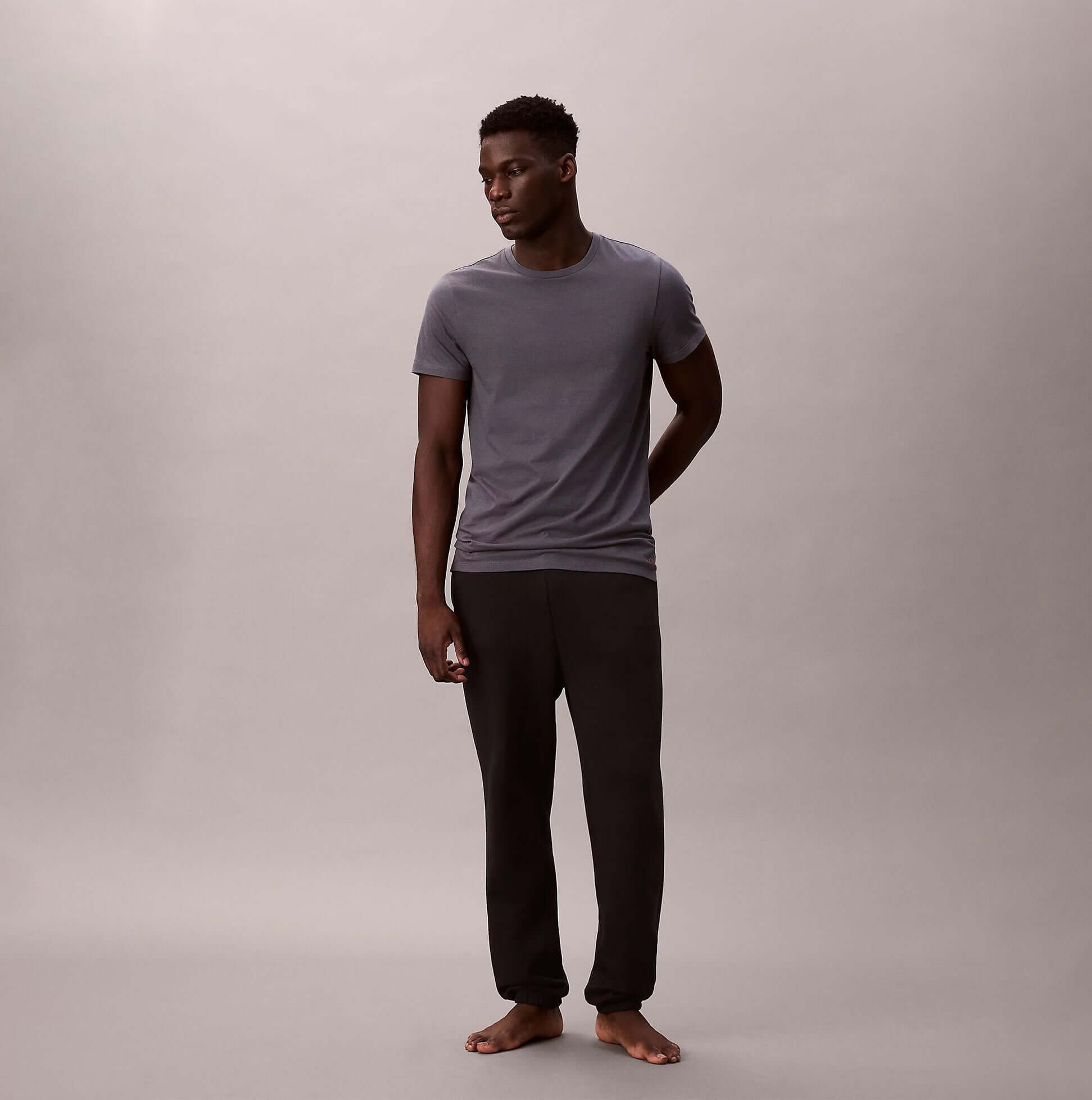 Calvin Klein S/S CREW NECK 3 PACK Mens T-Shirts & Tank Tops Multicoloured front view on model wearing grey t-shirt and black pants.