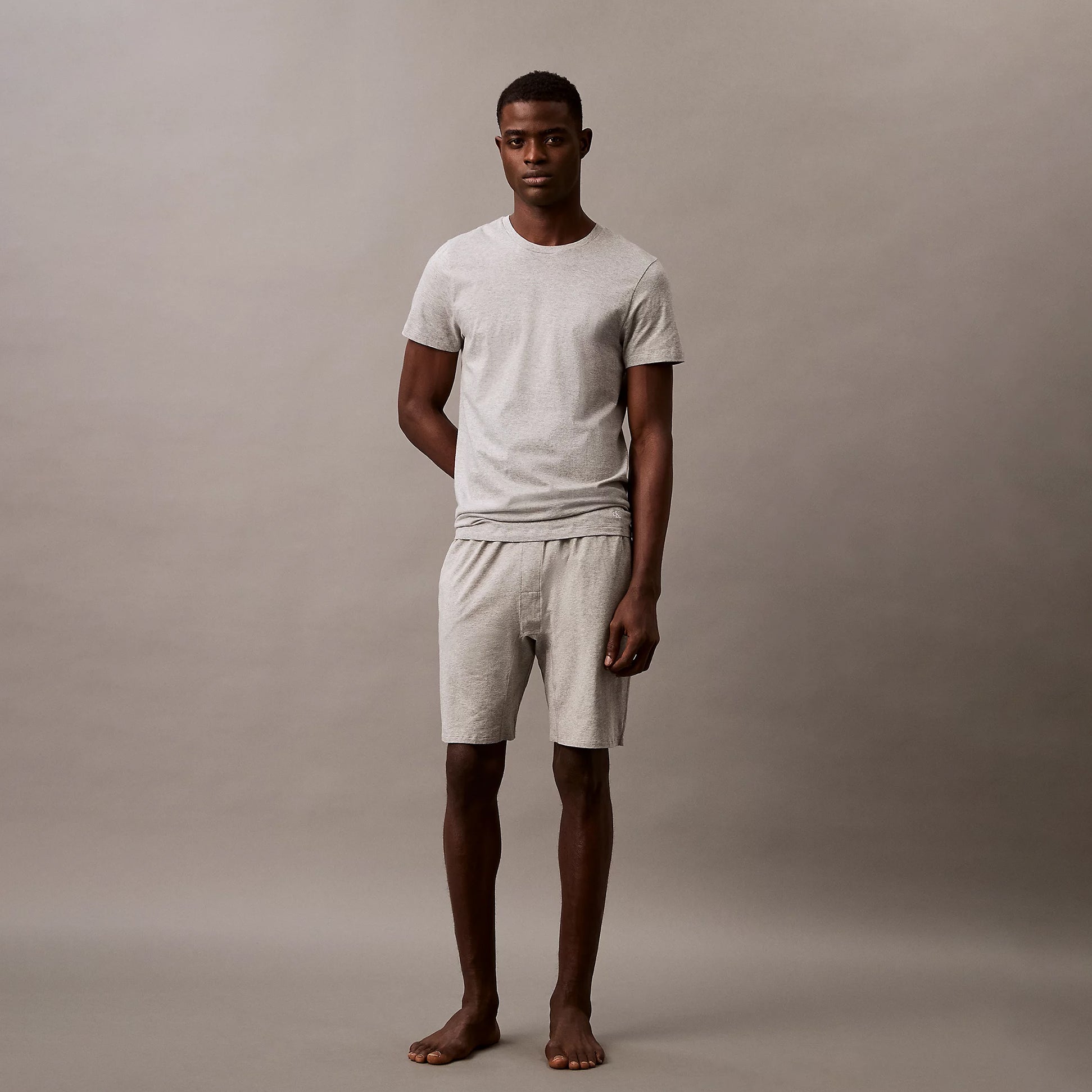 Calvin Klein 100% COTTON 3 Pack Mens T-Shirts Black/Grey Heather/Glacier front view of model wearing grey t-shirt and shorts.