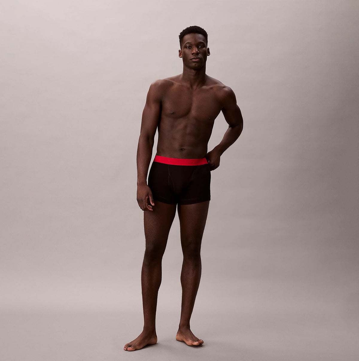 Calvin Klein TRUNK Mens 5 PACK Multicoloured front view shirtless model wearing black trunks with red waistband.